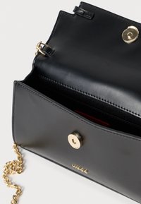 Mustast nahast rihmkott kuldsete detailide, kettremmi, magnetilise sulgumise ja tekstuurse voodriga sisemusega.