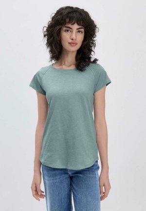 Hellgrünes kurzärmliges T-Shirt mit Rundhalsausschnitt, aus weichem Stoff gefertigt. Besitzt eine lockere Passform und einen abgerundeten Saum. Kombiniert mit blauen Jeans.