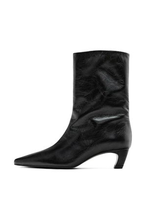Černý kožený kotníkový bot s špičatou špičkou a středním podpatkem. Hladký povrch s jemnými vráskami, s elegantním siluetou a minimalistickým designem.