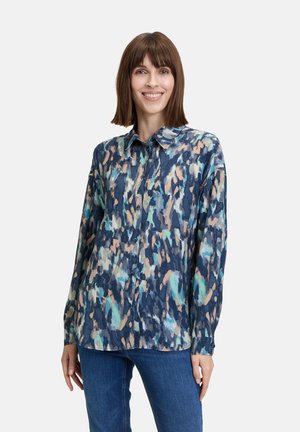 Langarmhemd in Marineblau mit einem abstrakten Druck in Teal, Pfirsich und Creme. Verfügt über einen klassischen Kragen und eine durchgehende Knopfleiste.