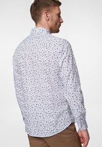 Biała koszula z niebieskim wzorem kwiatowym, długie rękawy i kołnierzyk zapinany na guziki. Charakteryzuje się dopasowanym krojem i gładką teksturą materiału.