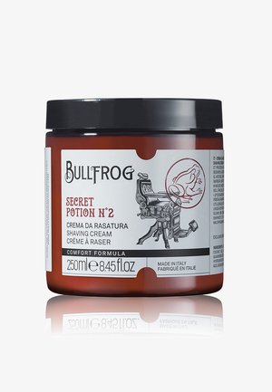 Braunes Glasgefäß mit schwarzem Deckel. Das Etikett zeigt schwarzen Text auf weißem Hintergrund, der den Produktnamen und Informationen detailliert sowie eine Grafik eines Friseurstuhls.