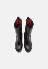 Zwarte leren enkelboots met een elegant ontwerp, elastische zijkanten en een bordeauxrode voering, met treklussen aan de achterkant voor gemakkelijke instap.