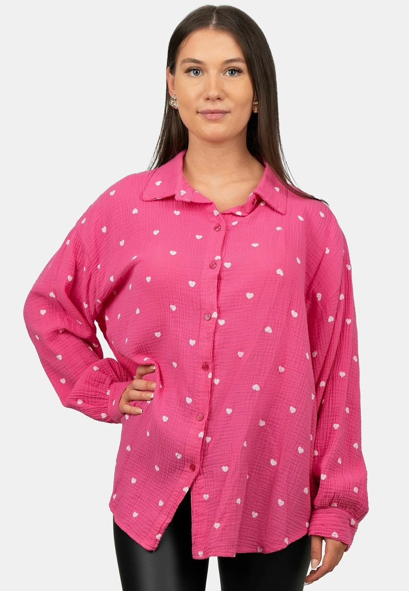 Camicia rosa con bottoni in tessuto testurizzato, decorata con motivi a cuori bianchi, dotata di colletto, maniche lunghe e spacchi laterali.