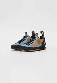 Blaue und braune Outdoorschuhe mit Gummisohle, strukturiertem Stoff, runder Zehenform und Zuglaschen; mit schwarzen Schnürsenkeln und einem kreisförmigen Logodetail.