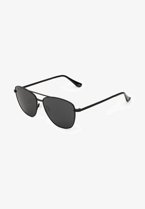 Schwarze Flieger-Sonnenbrille mit dunklen Gläsern, Metallrahmen, dünnen Bügeln und minimalistischen Design. Auffällige Markenkennzeichen auf dem Rahmen.
