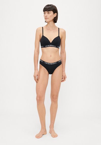 Melnas krūšturis un bikini komplekts ar regulējamām plānām siksnām, ar V veida kakla dizainu un zīmola elastīgu jostu. Gluda auduma tekstūra.