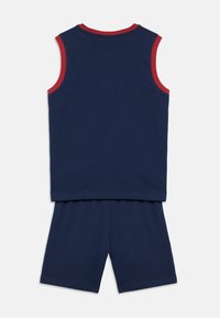 Μπλε σκούρο αμάνικο τοπ με κόκκινες λεπτομέρειες γιακά και αντίστοιχα σορτς, κατασκευασμένα από μαλακό ύφασμα, με απλό και άνετο σχέδιο.