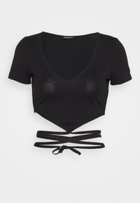 Top corto negro hecho de tela suave, con un escote en V profundo, mangas cortas y un detalle de lazo envolvente en la cintura.