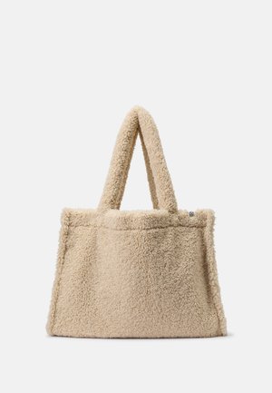 Beige rektangulær tote taske med blød, fluffy tekstur og to brede håndtag, designet til at blive båret i hånden eller over skulderen.