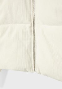 Cremfarbene Cordstoff mit strukturiertem, vertikal geripptem Muster; auf einer Seite mit einem metallischen Reißverschluss ausgestattet, mit glatter Oberfläche und klaren Linien.