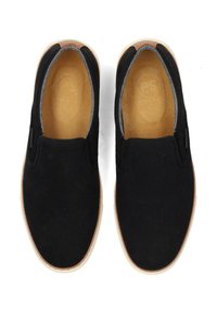 Schwarze Slipper aus Wildleder mit einer hellbraunen Gummisohle und elastischen Seiteneinsätzen für einfaches Anziehen. Durchgehend glatte Textur.