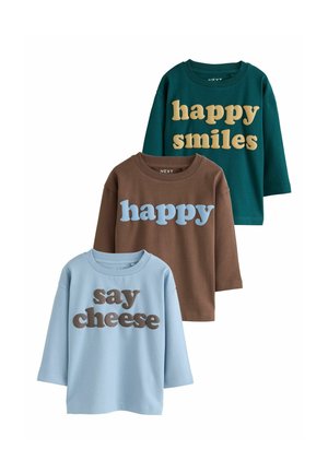 Trzy koszule z długim rękawem w kolorze morskim, brązowym i jasnoniebieskim z napisami "happy smiles," "happy," i "say cheese" nadrukowanymi z przodu.
