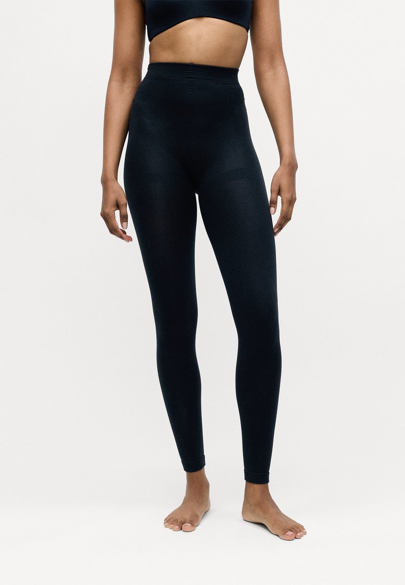 Hochtaillierte schwarze Leggings aus dehnbarem Stoff, mit glatter Textur und figurbetontem Schnitt, der bis zum Knöchel reicht.