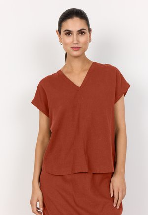 Rostfarbenes V-Ausschnitt-Oberteil mit kurzen Ärmeln aus strukturiertem Stoff, in lockerer Passform mit seitlichen Schlitzen, kombiniert mit einem passenden Rock.