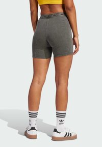 Gray ribbed shorts with a high waistband, paired with white striped socks and black-and-white shoes. Fabric has a soft texture.