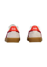 Un par de zapatillas Gola blancas y rojas con suelas de goma vistas desde atrás sobre un fondo blanco.