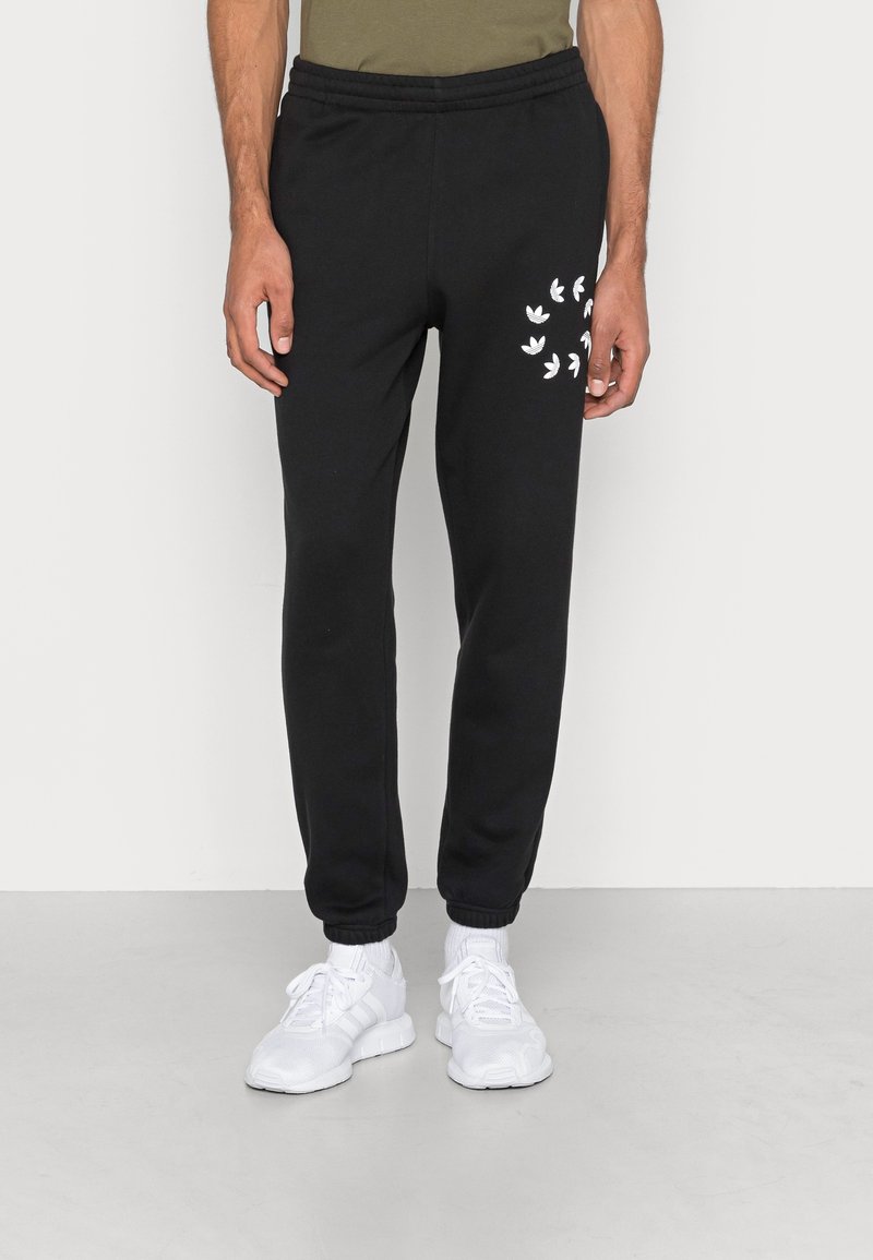 Pantaloni della tuta neri con vita elastica, con accenti del logo bianco coscia e caviglie a coste. Realizzati in tessuto morbido.