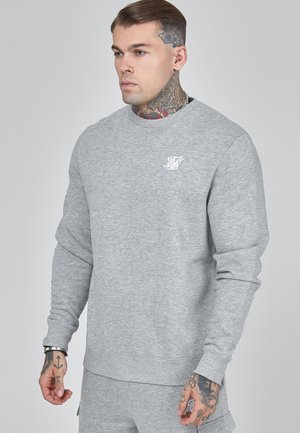 Grey sweatshirt made of soft fabric, featuring a crew neckline, long sleeves, and a small white logo printed on the chest.