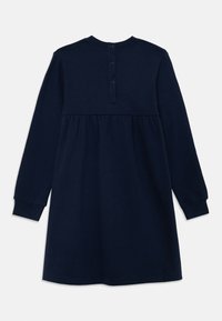 Abito lungo a maniche di colore blu navy realizzato in tessuto morbido, con gonna arricciata, scollatura rotonda semplice e chiusura con cinque bottoni sul retro.
