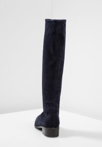 Stivali blu navy sopra al ginocchio in suede, con punta rotonda e tacco basso e spesso con dettagli di cucitura visibili.