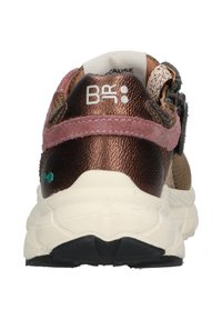 Bronzen en roze sneaker met textuurmaterialen, gewatteerde kraag, verstelbare band en patronen. Dikke witte zool met zwarte profiel.