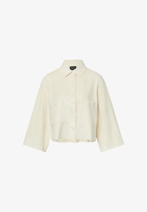 Kremowa krótka kurtka z długimi, szerokimi rękawami, zapinana na guziki z przodu, z klapkowymi kieszeniami na piersiach i zaostrzonym kołnierzem.