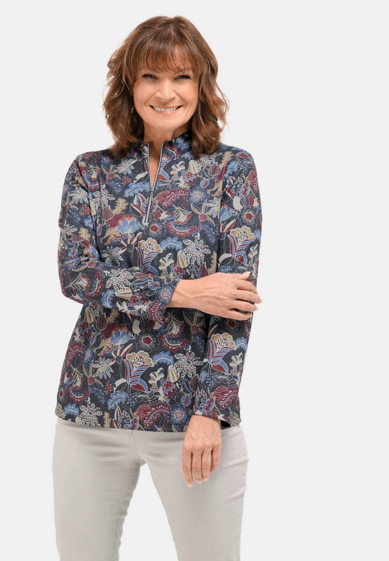 Pullover con motivo floreale e colletto alto, nei colori blu navy, rosso e crema. Realizzato in tessuto morbido con maniche lunghe e chiusura con zip.