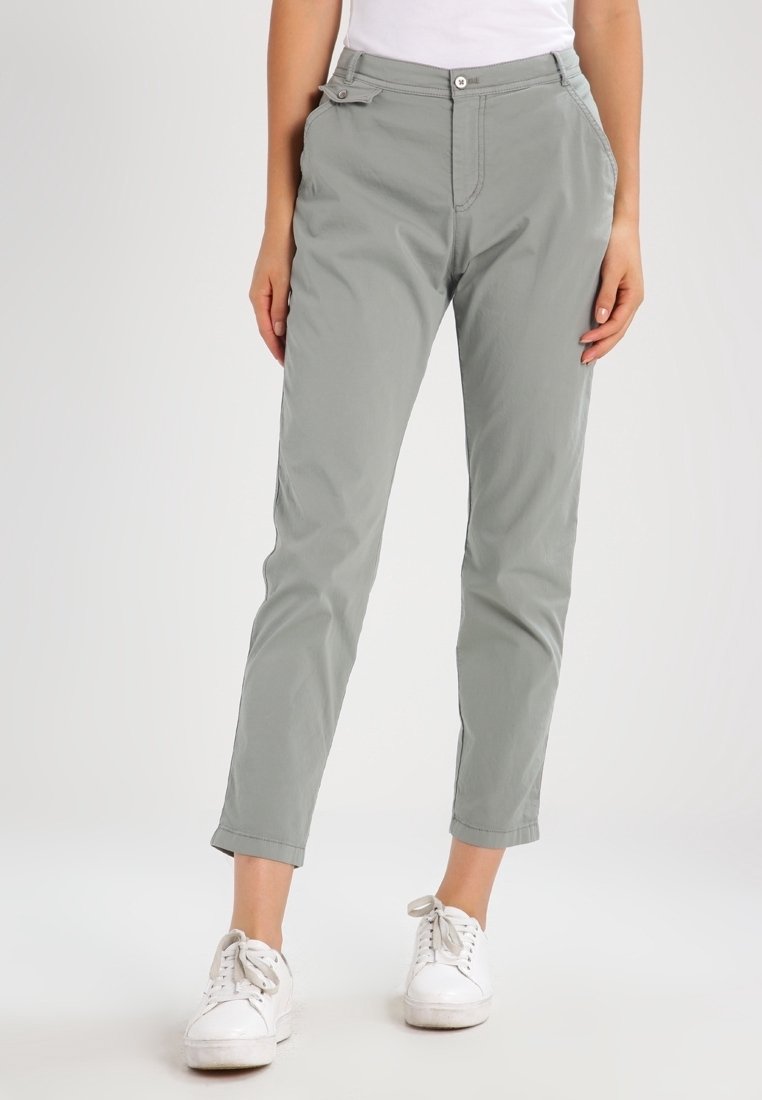 Jasnoszare, slim-fit spodnie wykonane z lekkiego materiału, z zamkiem i zapięciem na guzik, z przednimi kieszeniami i mankietami, połączone z białymi sneakersami.