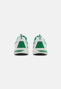 Sportsko-sneakers med en hvit mesh-overdel med grønne detaljer, polstret krage og en teksturert gummisåle for grep.