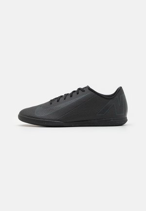 Zwarte sportieve schoenen met een gestructureerd oppervlak, gestroomlijnde vorm en vetersluiting. Bevat een subtiel logo en een rubberen zool voor grip.