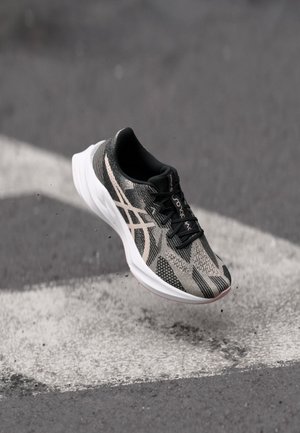 Schwarze und graue Laufschuhe mit einer strukturierten Oberseite, die ein Schnürdesign aufweisen und eine weiße Sohle haben. Mit reflektierenden Details akzentuiert.