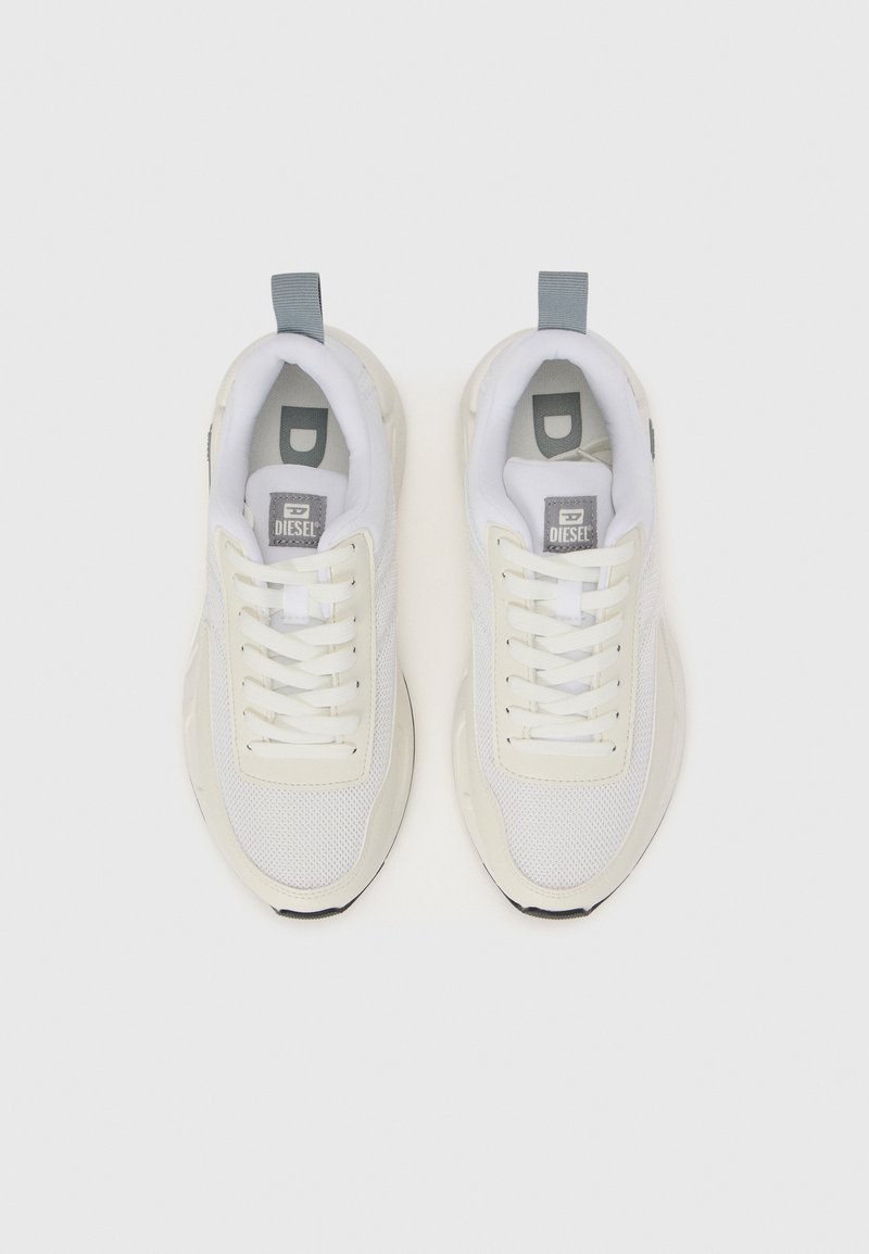 Baskets de sport blanches avec un dessus en maille, des lacets plats, un col rembourré, des accents gris et une semelle en caoutchouc épaisse avec des crampons noirs.