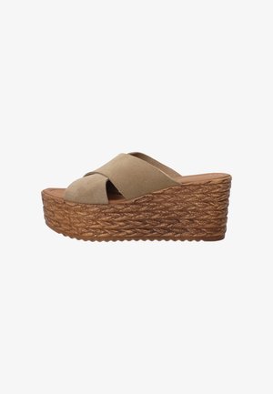 Beige wedge sandalen met een kruissluiting, zachte suede textuur en gevlochten jute zool. De hakhoogte is gematigd voor extra lift.