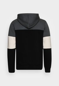Felpa con cappuccio di colore nero, maniche grigie e bianco sporco. Presenta una texture morbida e un design a pannelli a contrasto.