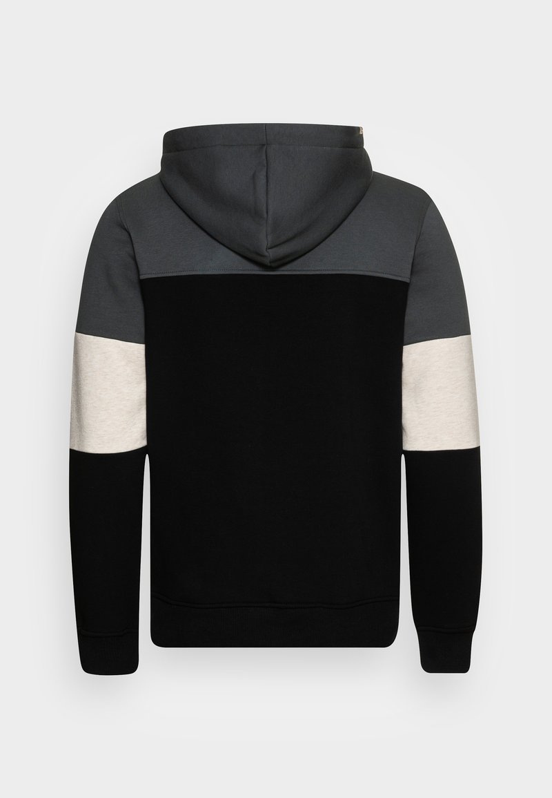 Sweat à capuche avec un corps noir, des manches grises et crème. Présente une texture douce et un design à panneaux contrastés.
