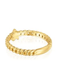 Anello in tonalità oro con design a catena intrecciata e banda liscia e lucida. Presenta un accento a forma di stella e dettagli incisi.