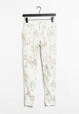 Jeans aderenti floreali con uno sfondo chiaro caratterizzato da foglie rosa e verdi. Realizzati in denim, presentano tasche anteriori e passanti per cintura.