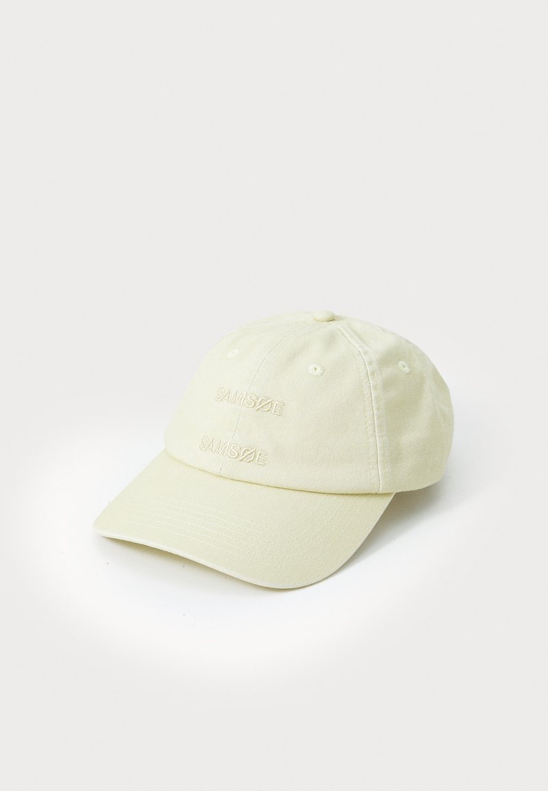 Light yellow baseball cap made of cotton, featuring embroidered branding on the front, curved brim, and six ventilation eyelets.