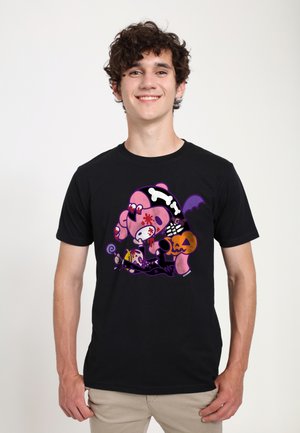 Giovane uomo che indossa una maglietta nera con una grafica a fumetti colorata a tema Halloween, comprendente un pipistrello viola, un osso di scheletro e un design a zucca.