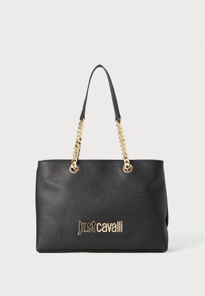 Svart tote veske med gullkjede skulderremmer, teksturert overflate og preget "Just Cavalli"-logo foran. Rektangulær form, romslig design.