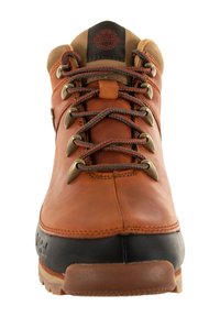 Botas de senderismo de cuero marrón con suela de goma negra, ojales metálicos, cordones gruesos, cuello acolchado y logotipo de Timberland en la lengüeta.