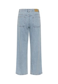 Jean en denim bleu clair à jambes larges vu de dos, avec deux poches arrière et une étiquette en cuir marron sur la ceinture.