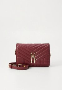 Sac à main en cuir rouge matelassé avec un logo doré, une chaîne et une bandoulière. Il présente un motif chevron et une forme rectangulaire. Fermeture à pression sur le dessus.