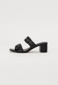 Svarta läderblockklack-sandaler med två breda remmar och rektangulära spännen, öppen tå-design och en slät, strukturerad yta.