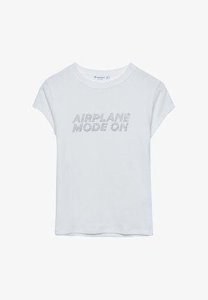 Weißes T-Shirt mit kurzen Ärmeln und Rundhalsausschnitt. Mit dem Text "AIRPLANE MODE ON" aus silbernen Strasssteinen. Weicher Stoff, lockere Passform.