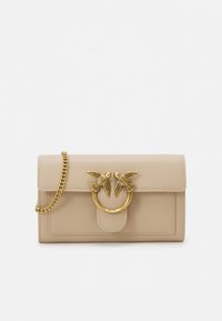 Beige skinnveske med klaffelukking, utstyrt med en metallring i gulltoner og to fugleornamenter. Inkluderer en skulderrem i gullkjede.
