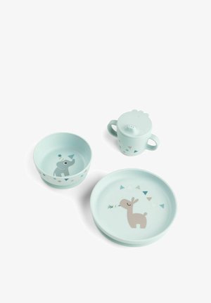 Vaaleansininen taaperon astiasarja, jossa kulhossa norsu, lautasessa peura ja kahvallinen tuttipullo, joissa on sama geometrinen kuviointi.