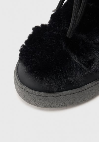 Pantofii cu blană neagră au o parte superioară netedă de culoare neagră și o talpă texturată de culoare gri, având o formă rotundă și un design căptușit.