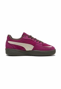 Sneaker in suede viola con accenti beige, suola in gomma testurizzata e lacci marroni. Presenta un design con striscia laterale curva.